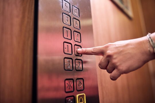 Person pressing elevator buttons in the building.