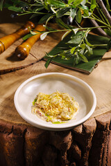 A beautifully arranged plate of asian cuisine featuring tender ingredients garnished with fresh herbs sits on a rustic wooden table. The setting highlights the natural textures of the environment.