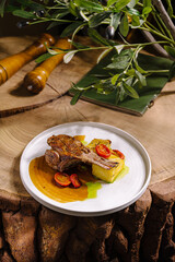 Juicy grilled meat served with tomatoes and sides on wooden table