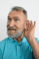 Elderly man's hand near his ear, which he has placed to his ear to better hear voices and sounds. Hearing problems in elderly