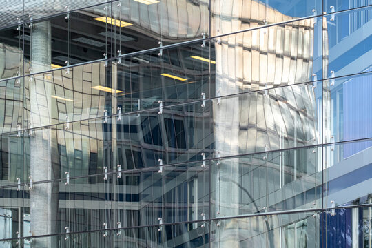 Glass facade reflection architecture featuring interior light and structure pattern within modern office building design showcasing transparency and depth in dense urban environment