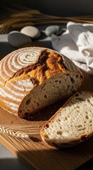 Freshly baked sourdough bread on a wooden board with a slice cut, showcasing its airy texture and crust