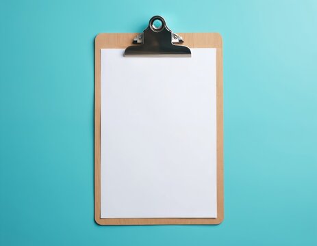 Empty clipboard with white paper rests on bright blue background. Top view of wood board holds blank sheet for notes or messages. Minimal office workspace concept.