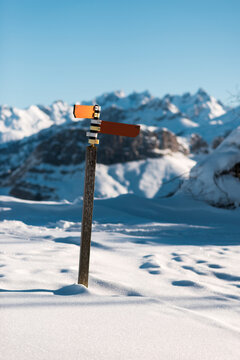 Hiking signpost in alpine snowy terrain
