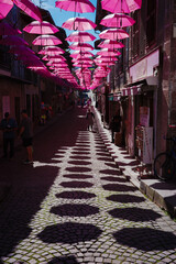 street scene with pink umbrellas, France