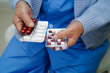 Asian elderly woman holding pill drug in hand, strong healthy medical.