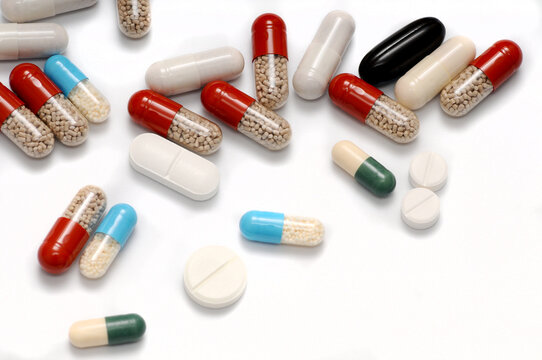 Pills Scattered on a White Background &ndash; A Visual Metaphor for Addiction and Health Risks