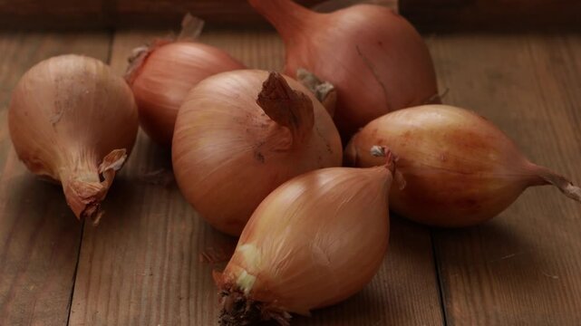 uncooked onios on wooden surface food close up zoom