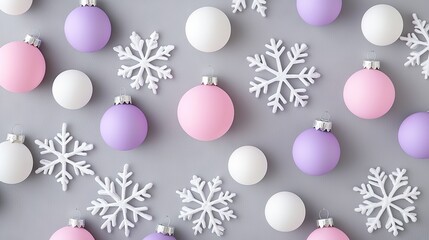 Fototapeta premium Festive pastel-colored christmas ornaments with snowflakes arranged on a grey background for holiday decoration