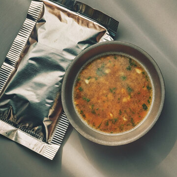 Foil packet and bowl of savory soup with vegetables