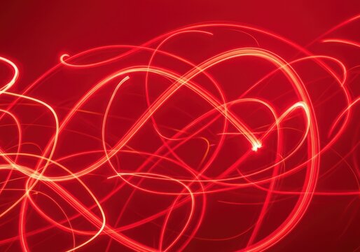 Abstract red light trails creating a dynamic and energetic swirling pattern against a dark background, evoking a sense of motion and excitement - Powered by Adobe