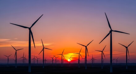 Obraz premium Breathtaking golden sunset over wind farm offers a powerful visual for clean energy campaigns and sustainable business initiatives, creating an optimistic mood.