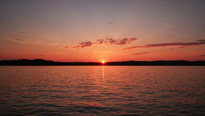 Obraz premium Vibrant sunset casting red hues on lake's reflective surface, seasonal change