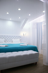 Holiday apartments. Four-poster bed. Protection from light and midges. Cozy bedroom in bright colors. Concept of recreation and travel.