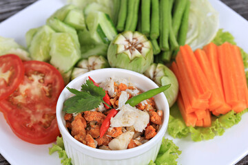 Spicy Crab Roe Relish Paste serve with Mixed fresh vegetables on vintage wood background