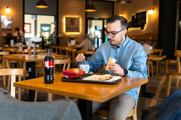 Young man enjoying casual lunch at restaurant