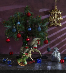 Wooden horses and Christmas toys on the branches of the Christmas tree. Festive mood. Waiting for the Christmas miracle.