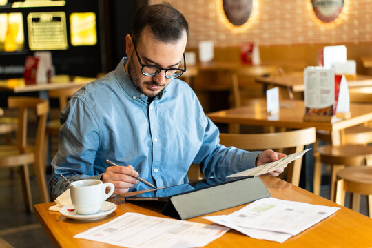 Man reviewing financial statements in a restaurant