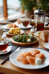 Healthy breakfast spread with salmon, salad, and tea on a sunny morning
