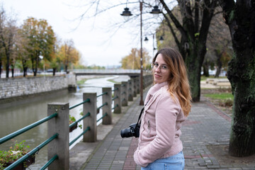Cute woman photographer by the quayside, portrait in autumn
