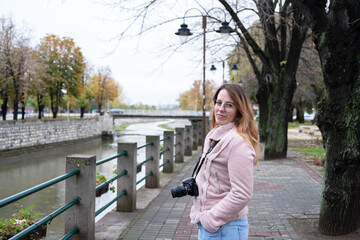 Cute woman photographer by the quayside, portrait in autumn