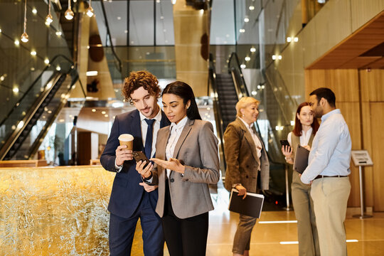Professionals engage in discussion at a modern office lobby during a busy workday - Powered by Adobe