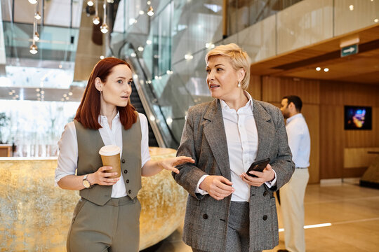 Two professionals engage in discussion while walking through a modern business office space