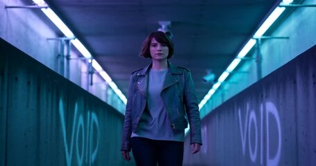A woman walks through a neon-lit tunnel with graffiti, creating a mysterious and urban atmosphere - Powered by Adobe