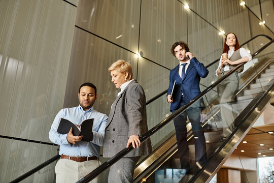 Professionals chat on a modern office escalator during the day - Powered by Adobe