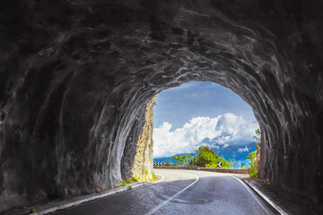 Curved road through tunnel with view of Garda Lake landscape in Italy
