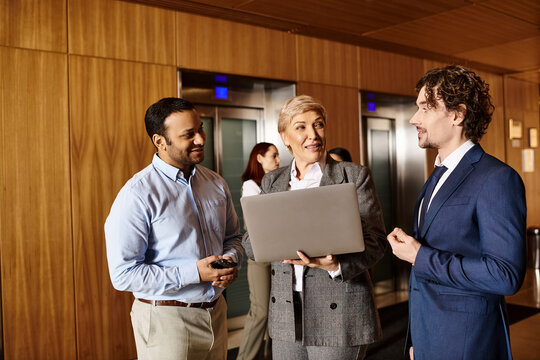 Colleagues share insights and ideas while collaborating on a laptop in a sleek office setting