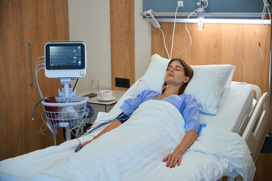 Woman receiving intravenous therapy while resting in hospital bed - Powered by Adobe