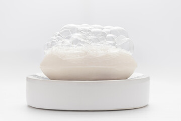 White soap with soap foam on white background. Cleanness concept