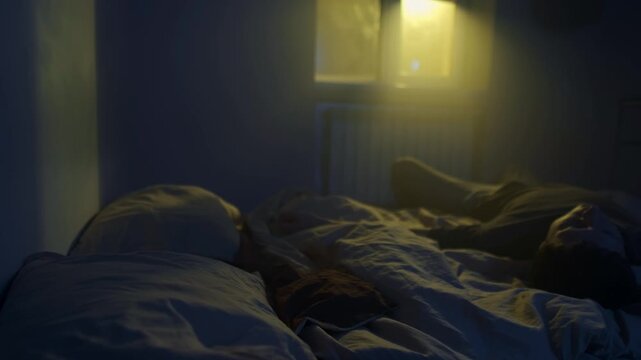 Man sitting alone on bed in dark room, emotional exhaustion and disappointment with life