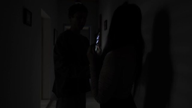 Jealous boyfriend suspects secret texting and tries to grab his girlfriend phone. They struggle for the phone, showing distrust, jealousy, emotional tension and relationship problems.