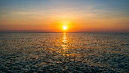 Sunset over water with yellow hues, reflecting light patterns on the surface