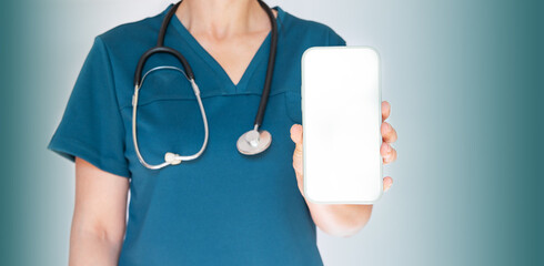An indistinguishable woman doctor with a stethoscope, holding a modern smartphone with a blank screen in close-up.Copy space.