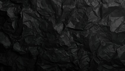 Surface of dark crinkled paper with irregular folds
