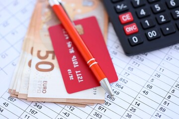 Credit card and pen with euro currency money bills banknotes on calculations document background. Business, financial operations and accounting in European Union