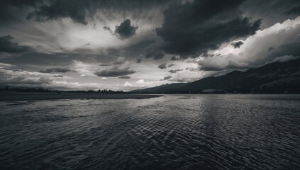 Obraz premium Monochrome river beneath an overcast sky, erosion risk