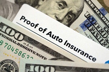 Proof of auto insurance card and many hundred dollar bills. Concept of insurance policy and car...