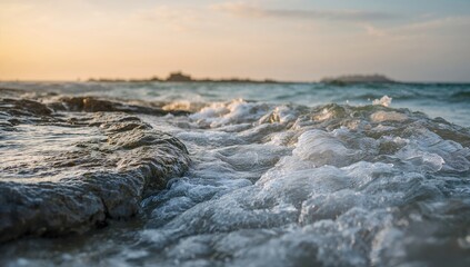 Obraz premium Ocean waves crashing against wet rocks, showcasing erosion risk