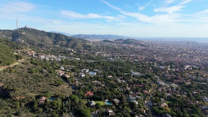 Barcelona cityscape showcasing the diverse urban landscape from an elevated perspective, featuring residential neighborhoods, sports facilities, and the sea under a clear sky
