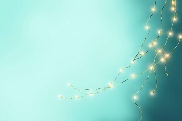 Glowing Christmas lights on turquoise background. New Year decoration with led garland on floor with copy space, selective focus