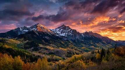 Majestic mountain range with snow capped peaks under a dramatic sunset sky mountains