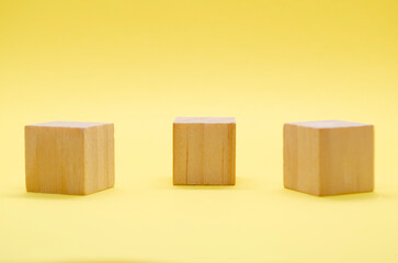 Close up view of isolated wooden cube with customizable space for text or ideas on yellow background. Copy space concept.