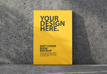 Soft cover book mockup front view with shadows from plant