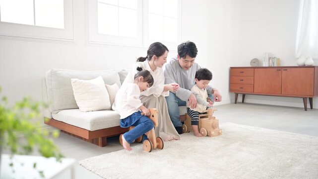 仲良し家族の子育て・育児の日常　リビングでの子供のお世話全身　見守る夫婦