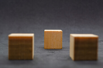 An isolated wooden cube on black cover background with customizable space for text or ideas. Copy space concept.