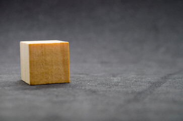 An isolated wooden cube on dark background with customizable space for text or ideas. Copy space concept